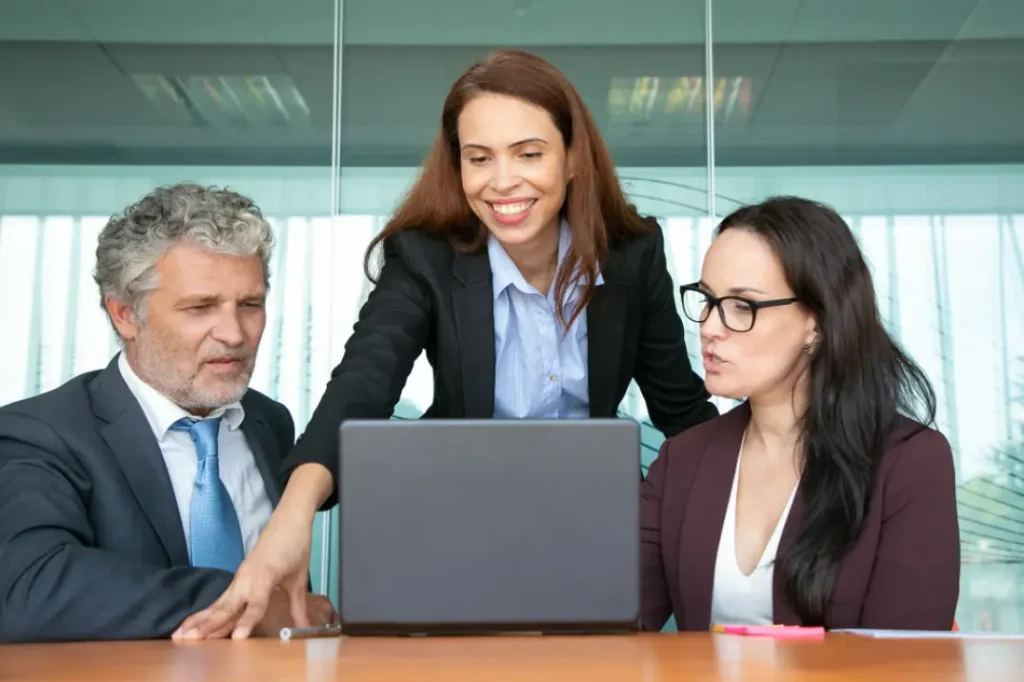 A team of 3 looking in a laptop
